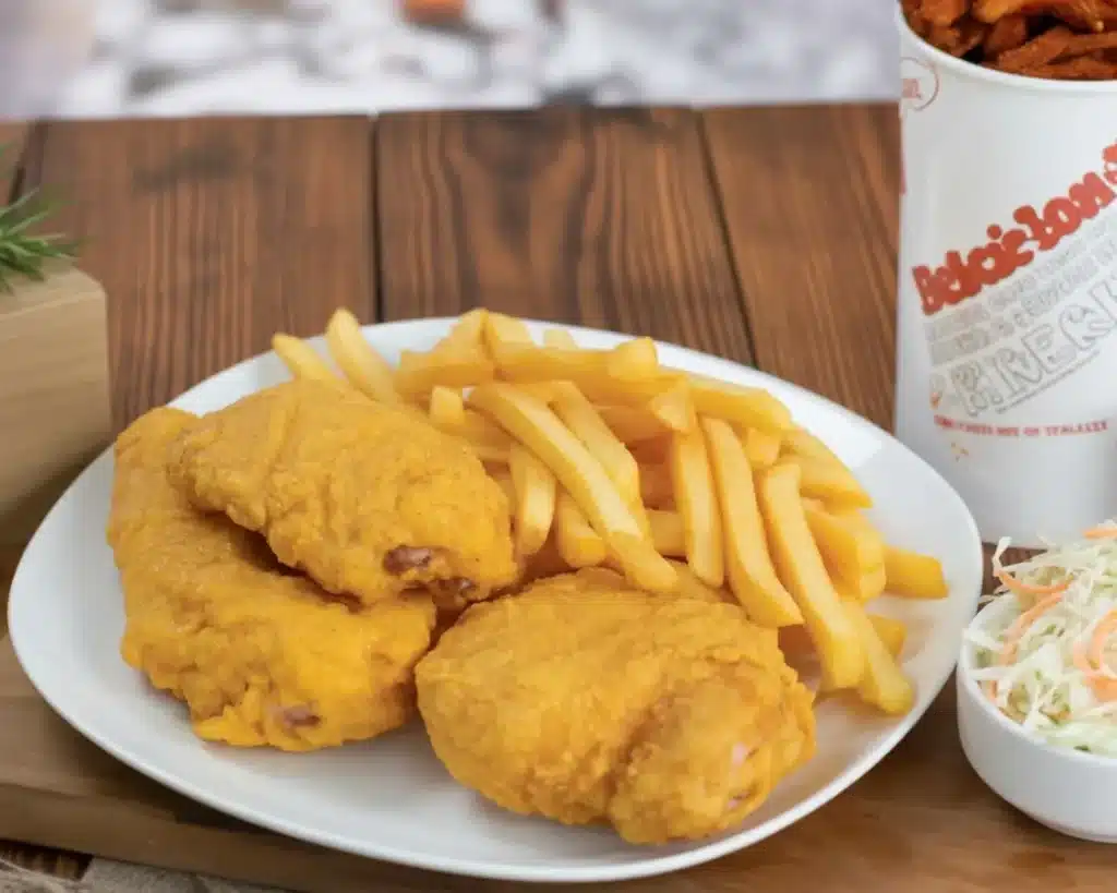 A tempting plate of Hip Hop Chicken with seasoned fried chicken and sides.