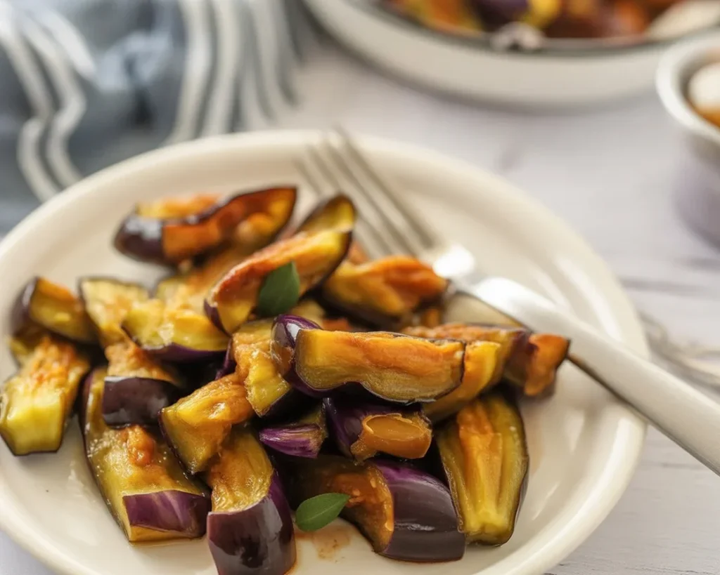 Plate of crispy Low-Calorie Air Fryer Eggplant slices, perfectly seasoned and golden brown.